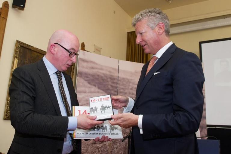 Defensieminister Pieter De Crem overhandigt een exemplaar van het boek en de film ‘Een klein leger in de Groote Oorlog’ aan de burgemeester van Dendermonde, Piet Buyse.